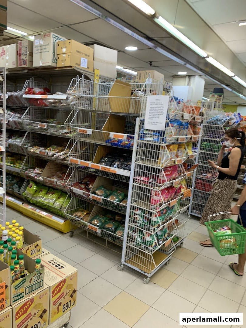 Interior view of a supermarket aisle stocked with various food products and snacks.