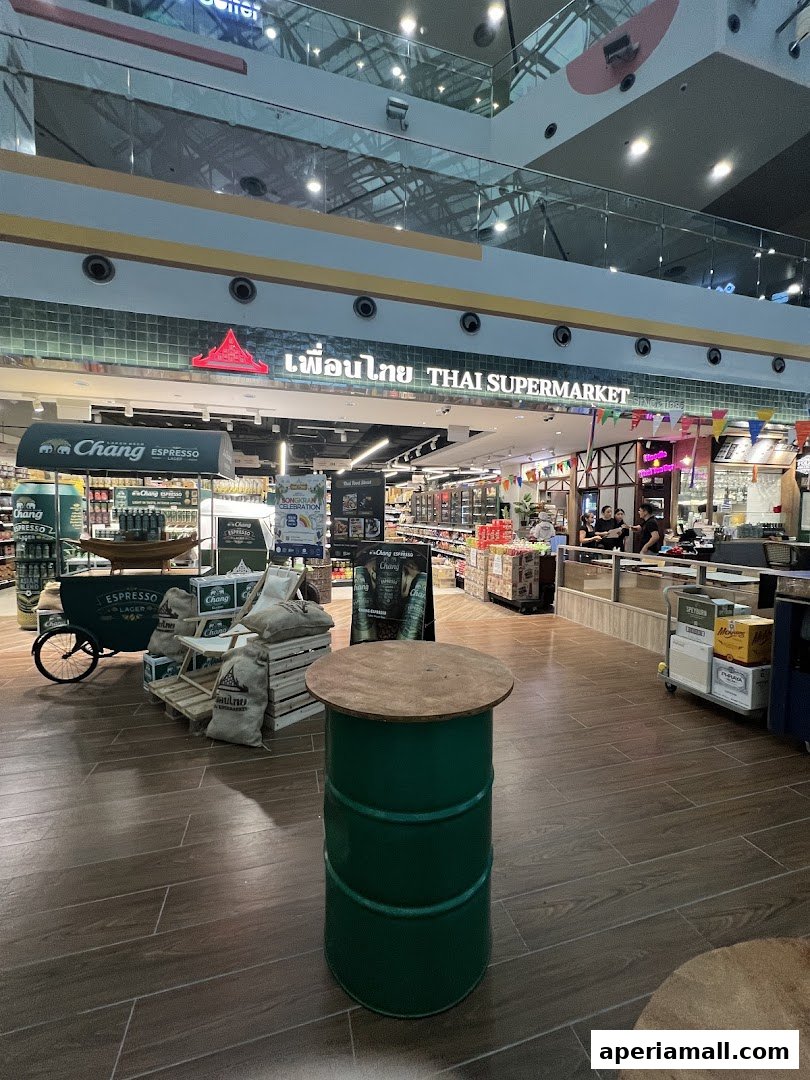 The entrance of Thai Supermarket with displays of Chang beer and espresso.