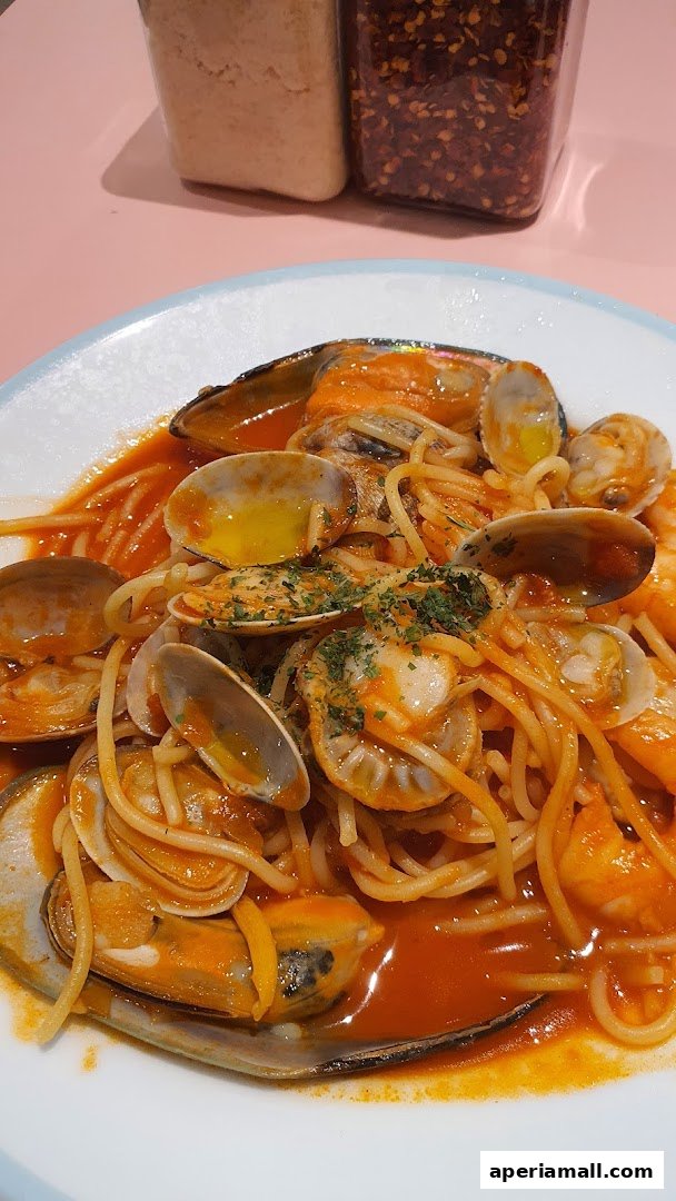 A plate of spaghetti with mussels, clams, and shrimp in a tomato sauce.