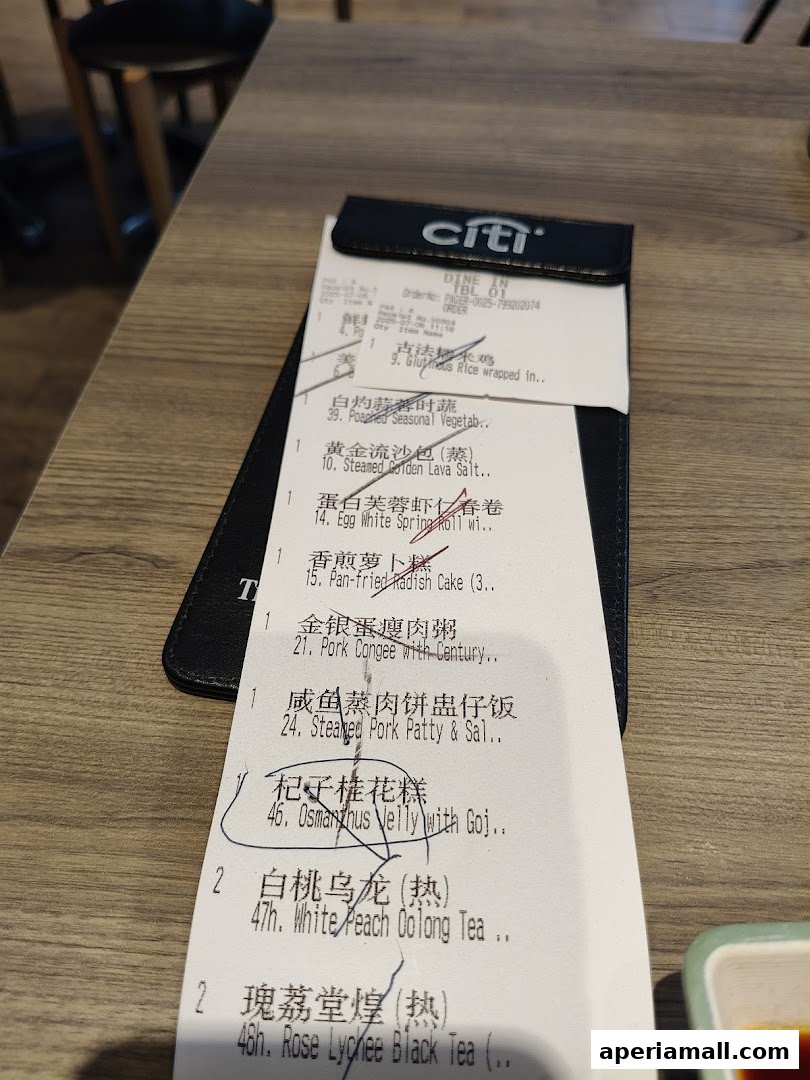 A close-up of a receipt from Tim Ho Wan showing various dim sum items and drinks.