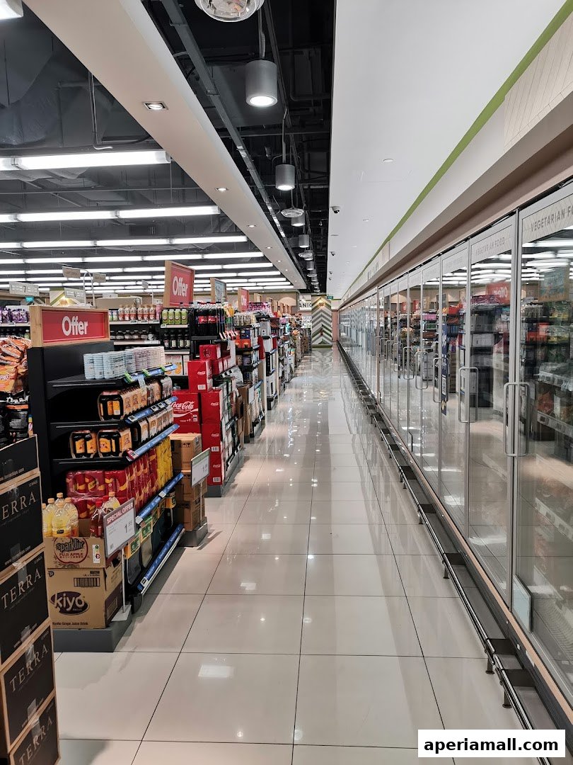 Aisle view of a well-stocked supermarket with shelves of products and refrigerated display cases.