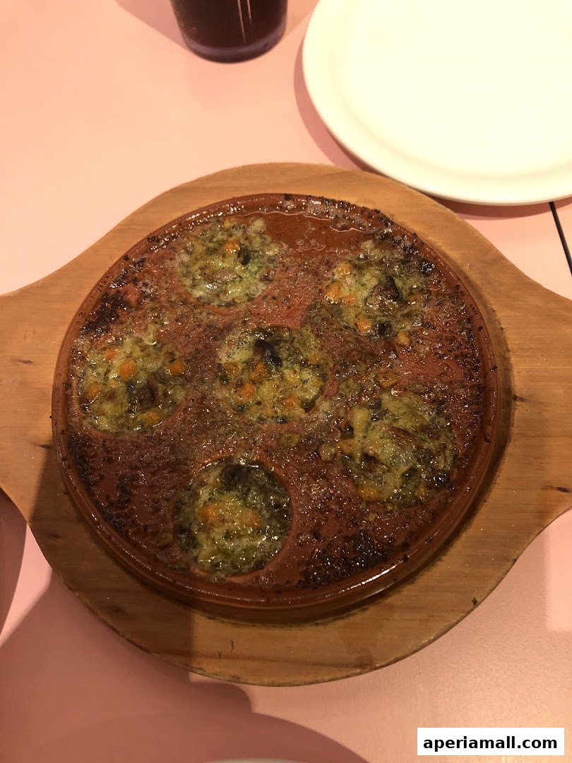 A close-up shot of escargots served in a traditional dish on a wooden board.