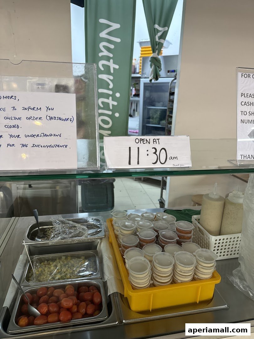 A display of fresh salad ingredients and sauces at a healthy food establishment.