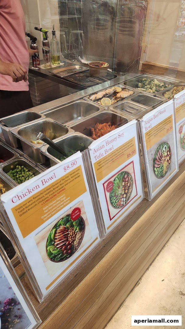 A display of healthy salad bowls with prices and descriptions at a food establishment.