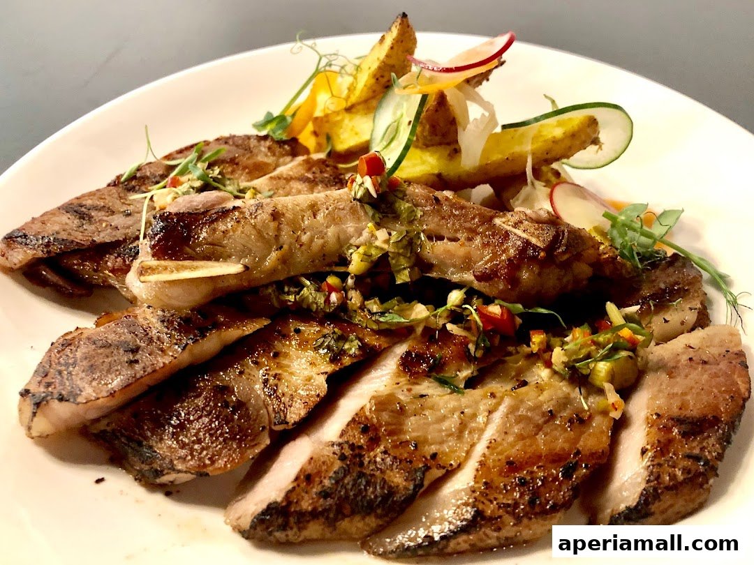 A plate of sliced grilled meat with fries and a fresh salad garnish.