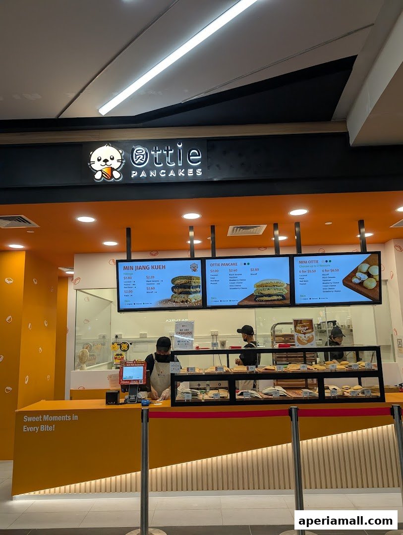 The Ottie Pancakes shop front with a bright orange counter and menu boards displaying pancakes.