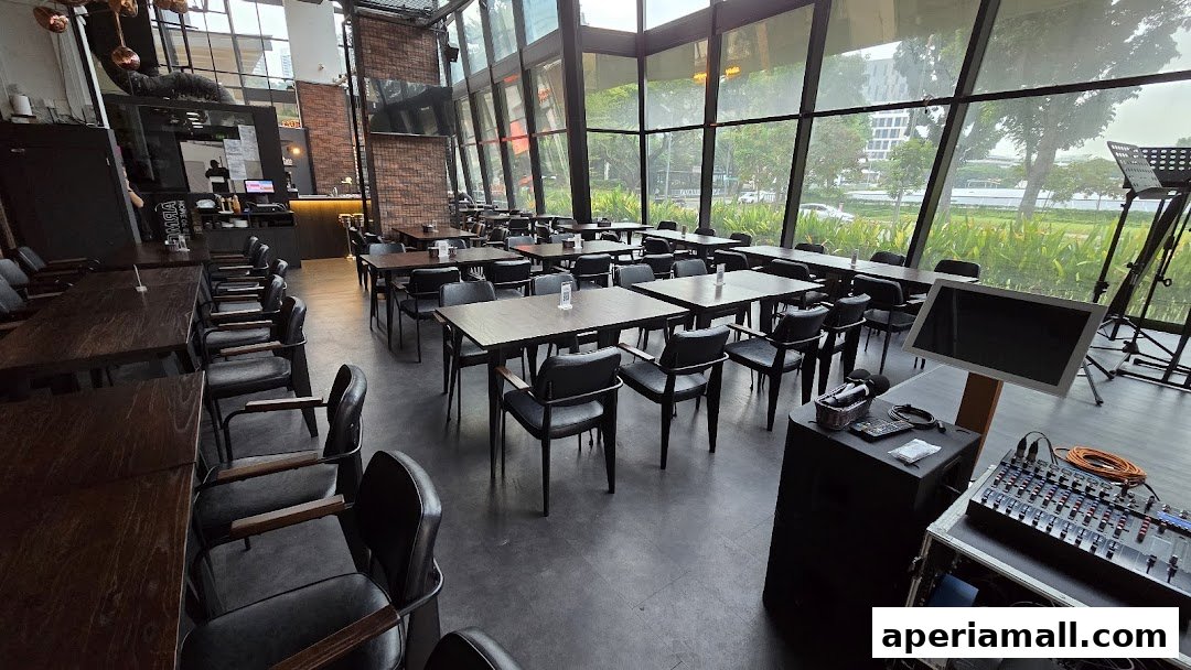 Interior of a modern restaurant with many tables and chairs, large windows, and audio equipment.
