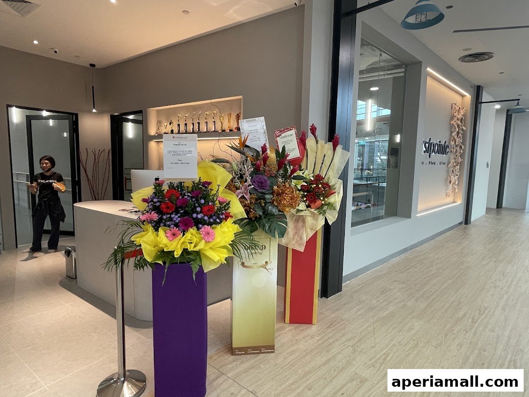 Interior of a dance school with a reception desk, floral arrangements, and the shop's logo.