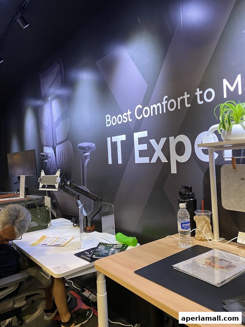 Interior of a showroom with ergonomic chairs and desks, featuring a motivational slogan.