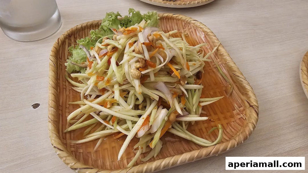 A close-up of a refreshing Thai mango salad served in a woven basket.