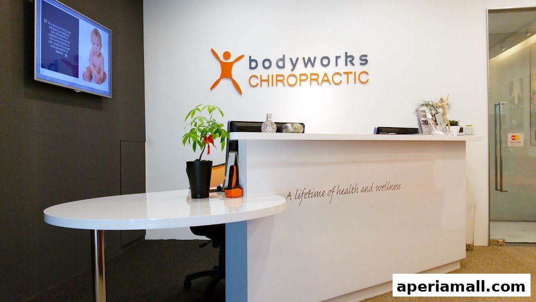 The reception area of Bodyworks Chiropractic Singapore, featuring a modern white counter and a motivational quote.