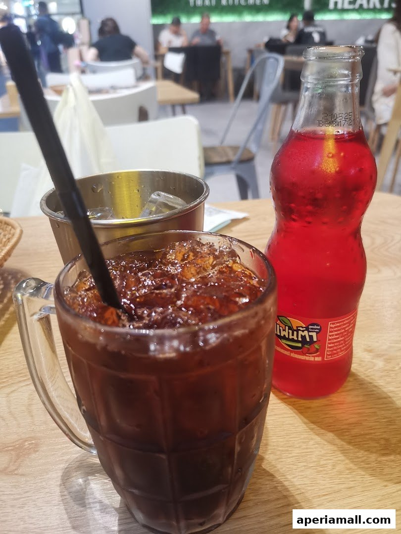 A close-up of iced drinks on a wooden table at Im-Em Thai Kitchen.