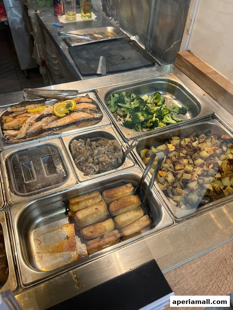 A display of various food items including salmon, broccoli, potatoes, and tofu.