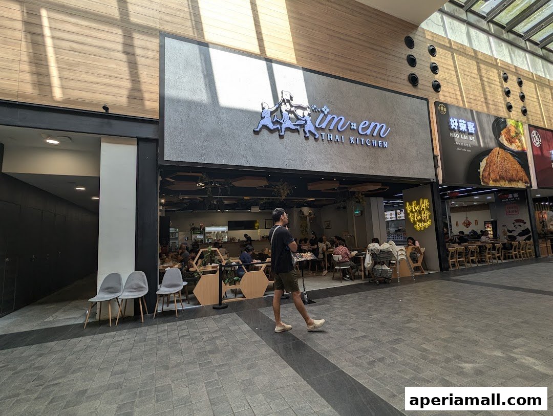 The exterior of Im-Em Thai Kitchen, a restaurant with people dining inside.