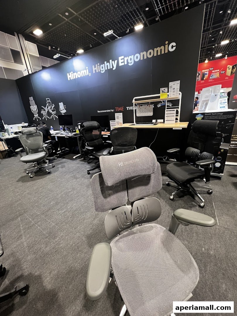 Hinomi showroom featuring ergonomic chairs and desks with a large banner highlighting their brand.