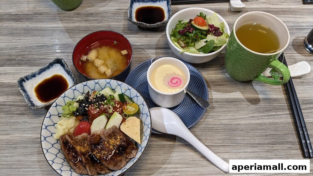 A delicious Japanese meal featuring donburi, miso soup, salad, chawanmushi, and tea.