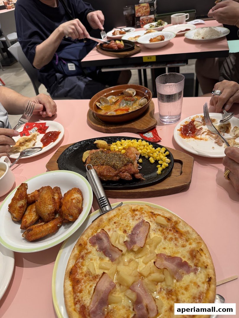 A table full of delicious food including pizza, chicken wings, and seafood stew.