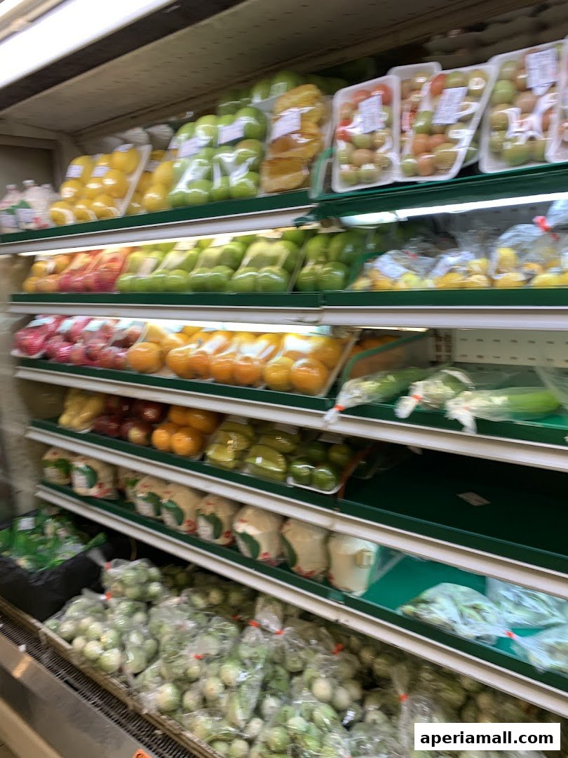 Shelves stocked with a variety of fresh fruits and vegetables, including apples, tomatoes, and corn.