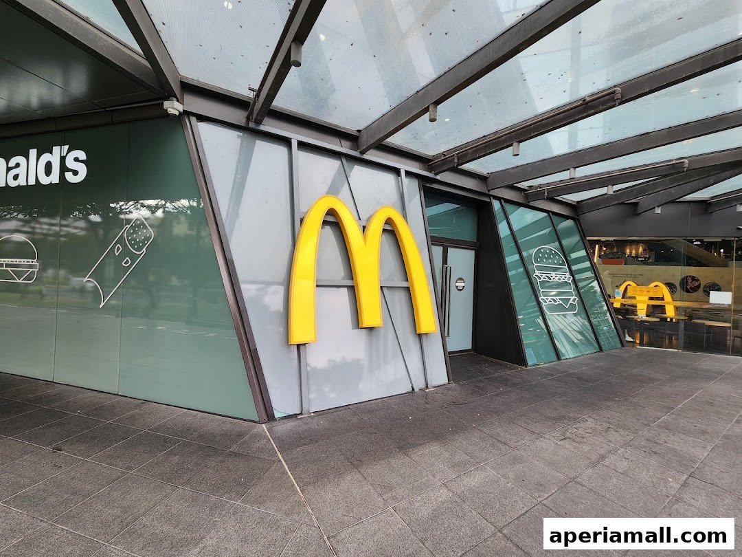 The exterior of a modern McDonald's restaurant with large golden arches and stylized burger graphics.