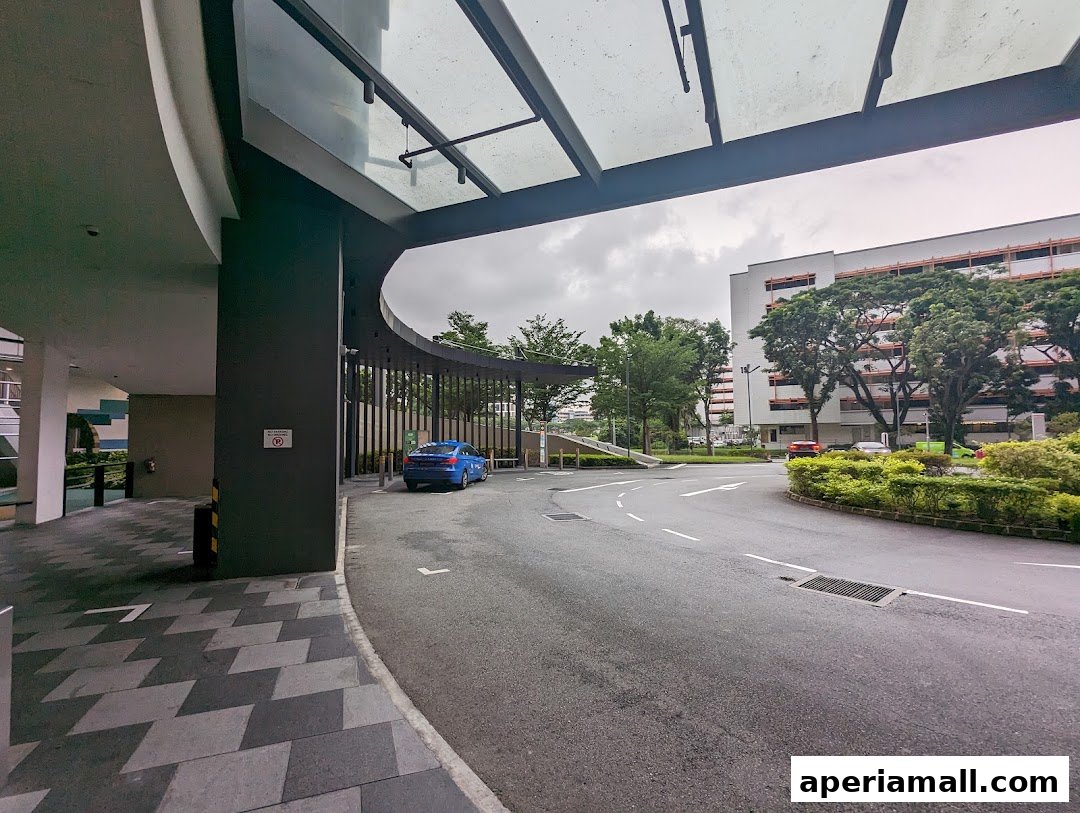 A blue car parked at the entrance of a modern building with a covered walkway.