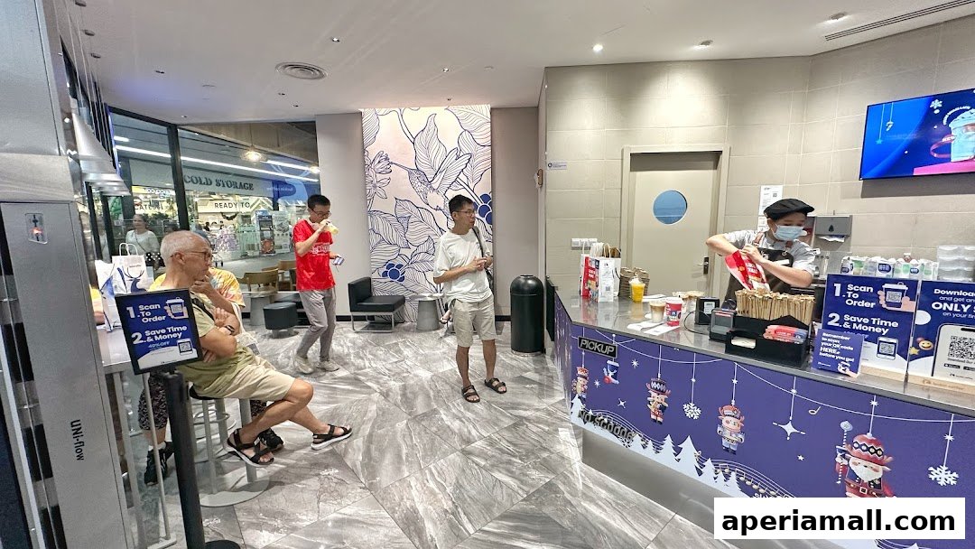 Customers at a Luckin Coffee counter with a barista preparing drinks.