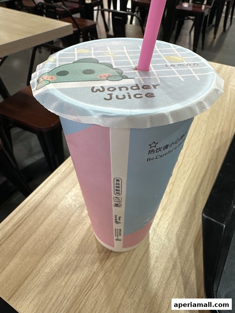A colorful cup from Wonder Juice with a cute dinosaur design on the lid.