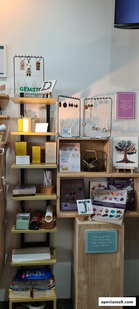 Shelves display crystals, jewelry, candles, and inspirational art.