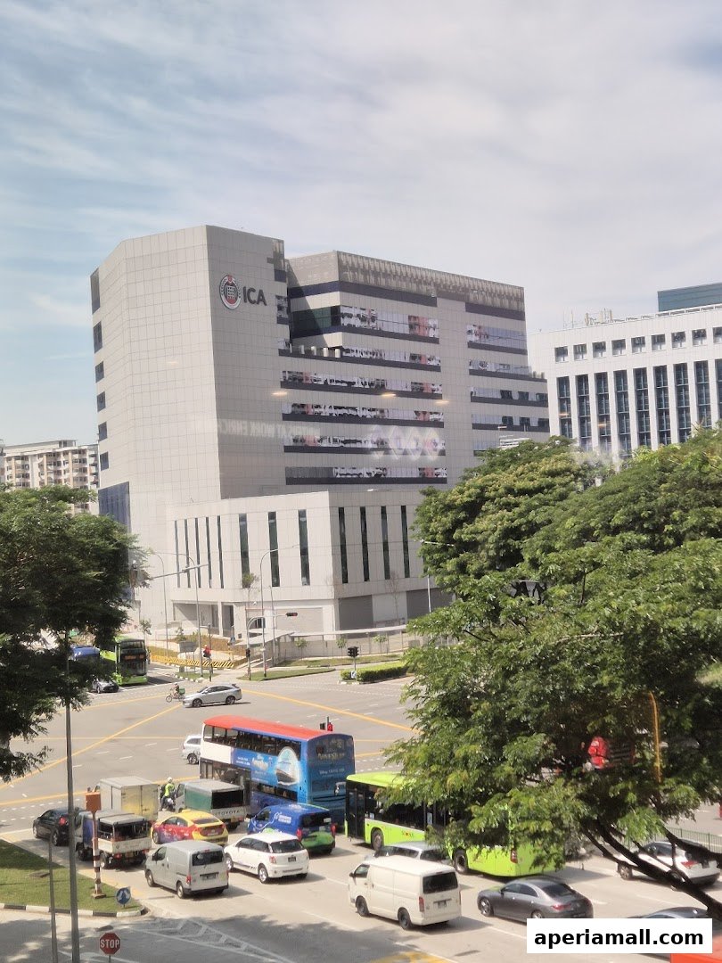 A modern building with the ICA logo, surrounded by trees and a busy street with traffic.