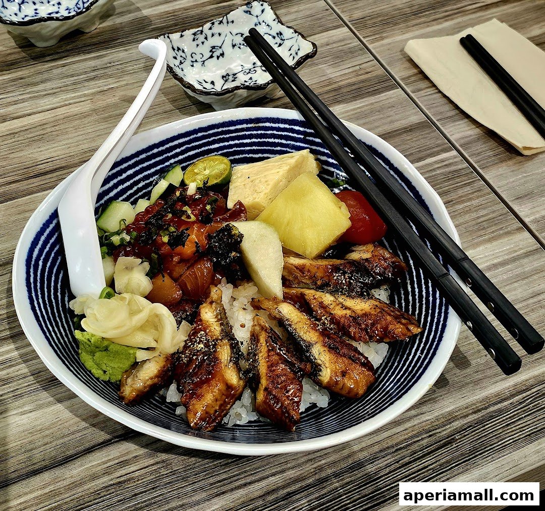 A delicious bowl of Japanese donburi with grilled eel, raw fish, and fresh vegetables.