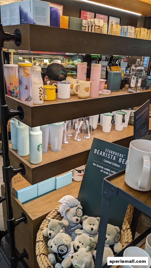 Starbucks store interior displaying merchandise including mugs, tumblers, and plush bears.