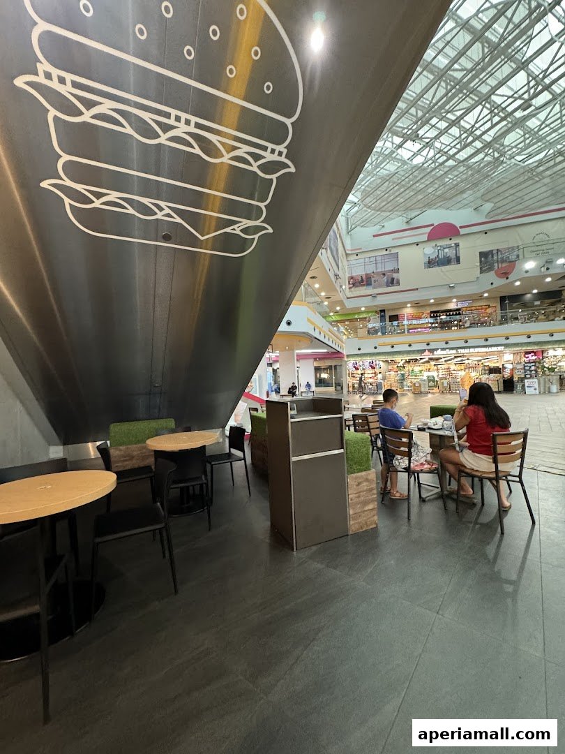Interior view of a McDonald's with seating area and a large burger graphic.