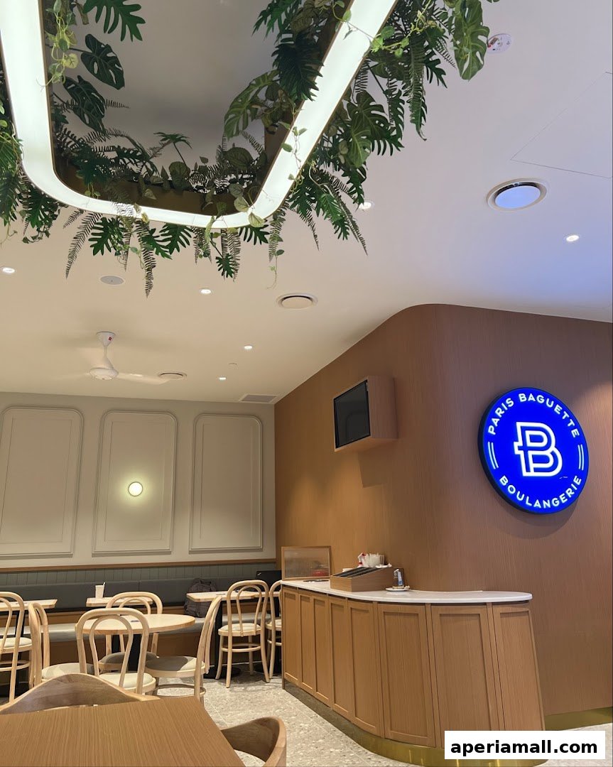 Interior of Paris Baguette with seating, counter, and branded signage.