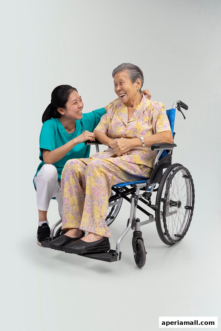 A caregiver smiles and assists an elderly woman in a wheelchair.