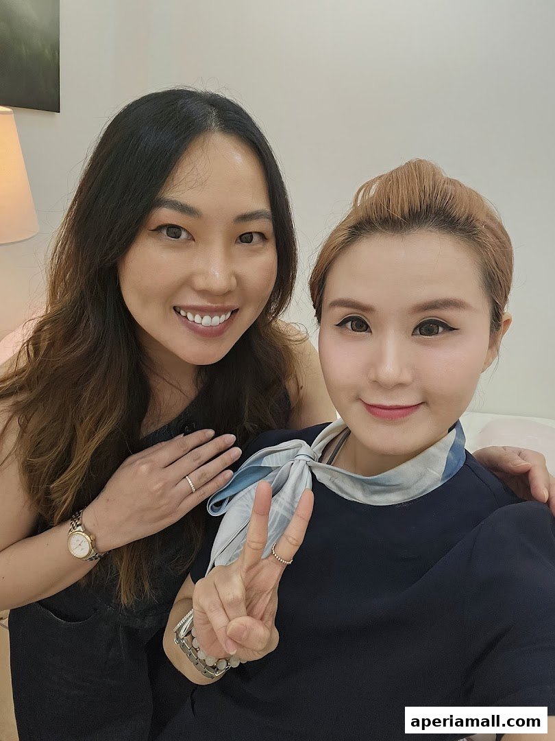 Two smiling women pose for a selfie, one making a peace sign.