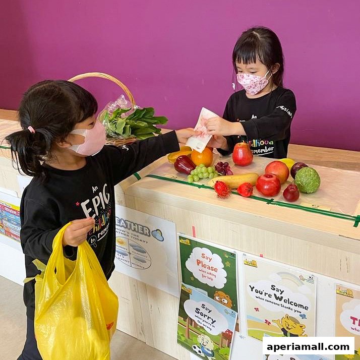Two children wearing masks are playing with fruits and money at a pretend store.