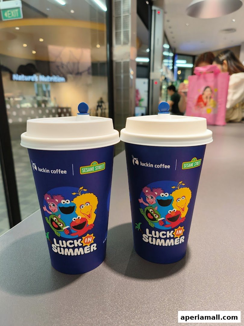 Two blue coffee cups with Sesame Street characters and 'Luck in Summer' branding.
