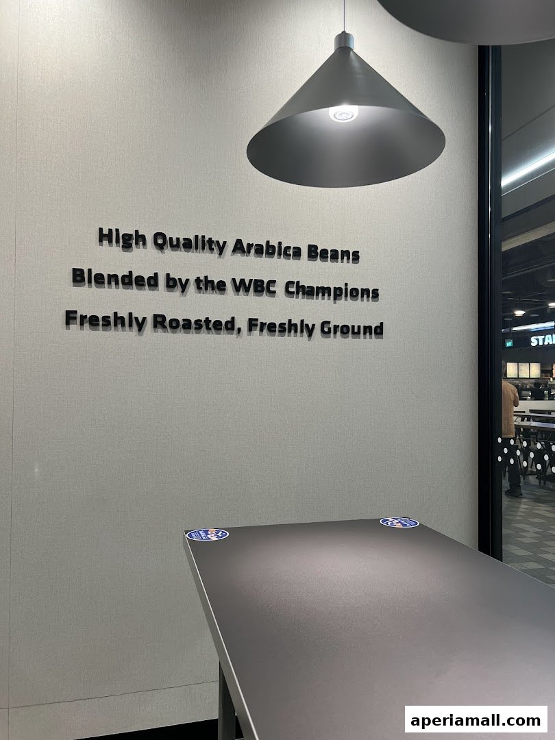 A wall with text about coffee beans and a table in front of a window.