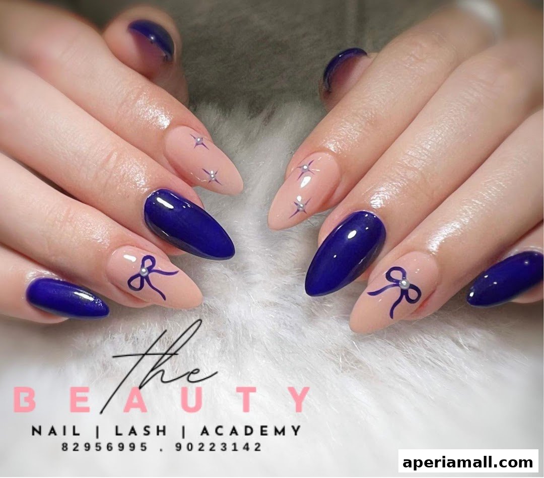 Close-up of hands with elegant navy blue and nude nails featuring bow and star designs.