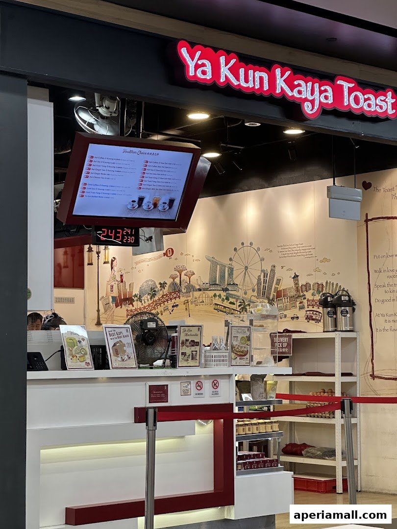 The Ya Kun Kaya Toast shop front with a digital menu and a Singapore skyline mural.