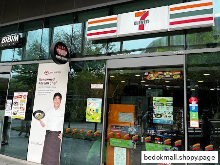 7-Eleven shop front with glass doors and promotional advertisements.