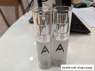 Two bottles of A Skin Pure Hyaluronic Serum displayed on a table.