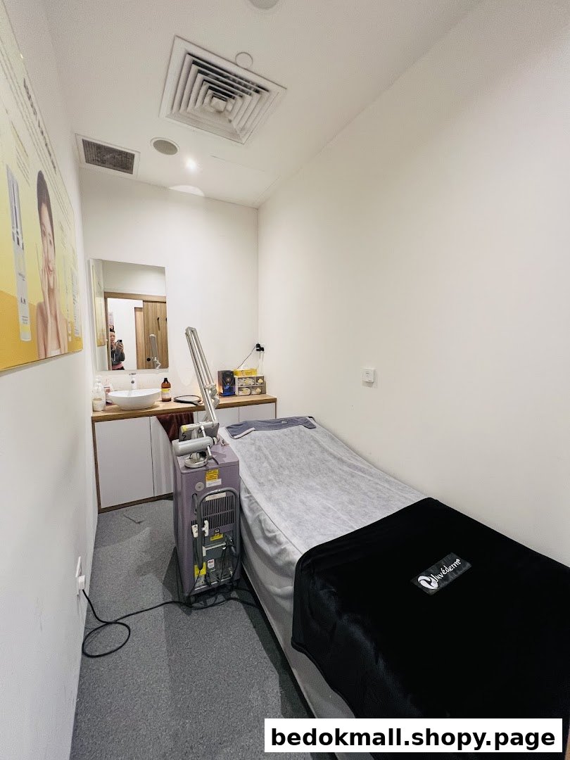 An aesthetic treatment room with a bed, sink, and specialized equipment.