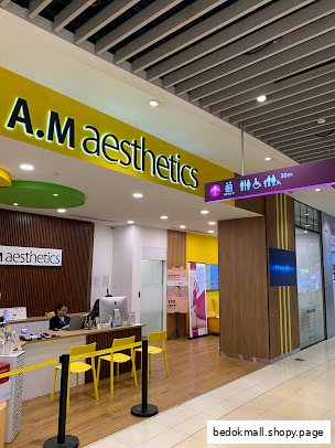 Entrance of A.M Aesthetics with reception desk and signage.