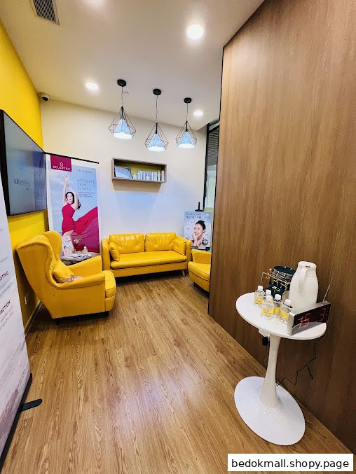Interior waiting area with yellow seating, promotional banners, and a small table.