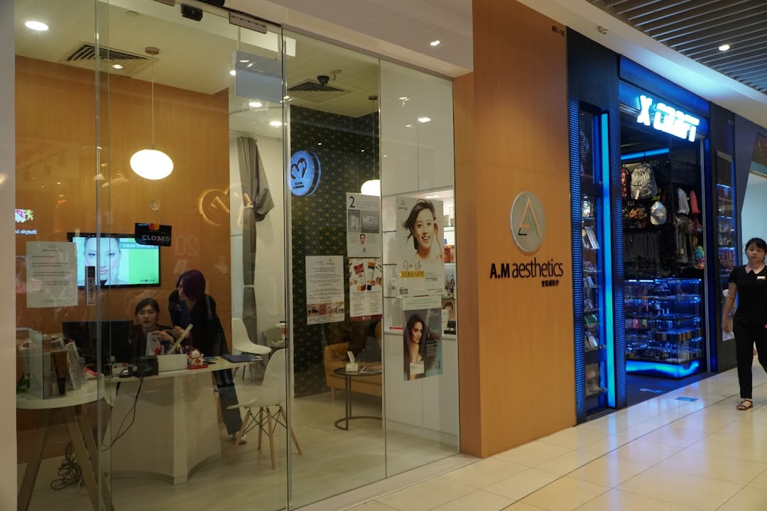 Glass shop front of A.M Aesthetics with staff and interior visible.