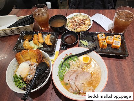 Table full of various Japanese dishes including ramen, gyoza, and sushi.