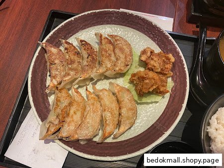A plate of gyoza and fried chicken with rice and soup.