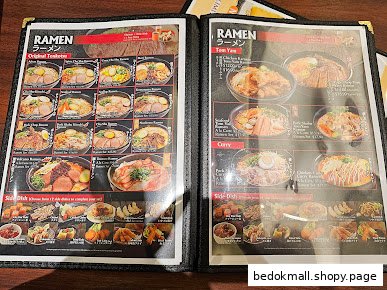 An open menu displaying various ramen and side dishes with prices.