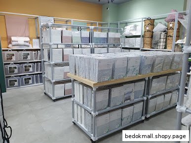 Interior view of a retail store with shelves displaying packaged bedding products.