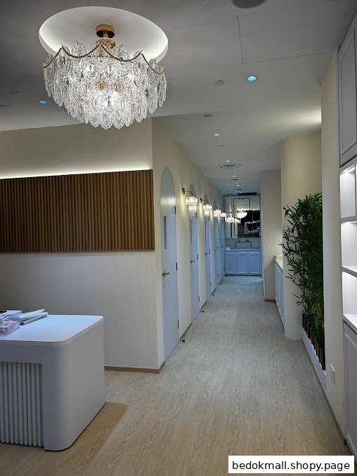 Interior hallway with multiple doors, a chandelier, and a reception desk.